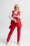 Young business woman in red casual pantsuit with office folder and handbag