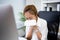 Young business woman is sick. She sneezes and coughs in the office