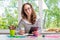 Young business woman sitting at table with tablet, remote work.