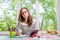 Young business woman sitting at table with tablet, remote work.