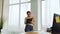 Young business woman standing near window and writing on clipboard