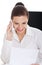 Young business woman with telephone, sitting by desk.