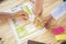 Young Business working woman hands showing report and wring a notebook on wooden table. stuff with notebook, post-it note ,