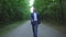 Young businessman in a blue suit is walking along the road in forest