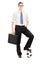 Young businessman with briefcase and football under his foot