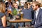 Young businessman and businesswomen drinking at a packed outdoor bar