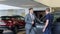 Young businessman choosing a new car together with dealer in auto salon