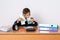 Young businessman is counting profit. On the table is a calculator, next to a mini shopping trolley, a clock and folders with