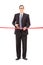 Young businessman cutting a red tape