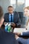 Young businessman with digital tablet having discussion with colleagues at conference table