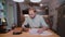 Young businessman with documents sitting at the table, working with papers and checking something on the phone.