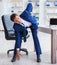 Young businessman doing sports stretching at workplace