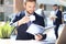 Young businessman drinking coffee in office while checking notebook.