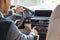 Young businessman driver sitting inside car turning conditioner on close-up back seat view