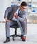 Young businessman exercising with elastic expander in office