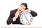 Young businessman falling asleep on a big wall clock