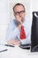 Young businessman with glasses and bald sitting in his office in