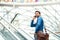 A young businessman going up escalator, talking on the phone. Copy space.