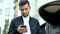 Young businessman holding modern mobile phone, man is typing sms, chatting