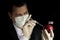 Young businessman injecting chemicals into an apple with Malaysian flag on black background