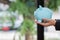 A young businessman or investor holds a blue piggy bank in her hand. The piggy bank is an idea for saving or accumulating assets