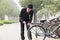 Young businessman locking up his bicycle on a city street in Beijing