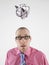 Young businessman looking up at piggy bank tied with rope representing trapped finances