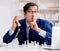 Young businessman playing glass chess in office