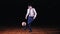 Young businessman plays soccer football on black background