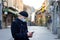 Young businessman with protective mask on face standing alone on empty street.