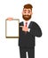 Young businessman showing blank clipboard and pointing index finger. Person holding notepad. Male character design illustration.