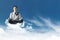 Young Businessman Siting on Cloud above the sky with Yoga meditation posture to find solution or wisdom, Supernatural photography