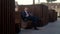 young businessman sits on bench in park during lunch break, holding tablet on which works. man in dark blue suit sits in