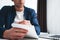 Young businessman sits by table and make business plan using notepad and pen