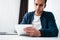 Young businessman sits by table and make business plan using notepad and pen