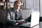 Young businessman sitting at desk with laptop