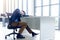 A young businessman sitting in a modern office. He has a feel sleepy because  hard work so tired weary fatigued and exhausted. On