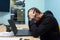 Young businessman sitting at the office table at work in depression. Problems, stress in the office, economic crisis