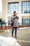 Young businessman standing in front of huge modern business building