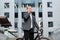 A young businessman standing on the steps of an office building, with a folder of papers and bike.Young handsome businessman talki