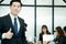 Young businessman standing thumb up in office meeting room, business concept