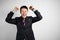 Young businessman in a suit on a gray background celebrating victory and success. Happy and excited expressing