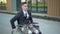 Young businessman in a suit in a wheelchair. A serious man is riding in a wheelchair against a business center. Special