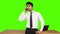 Young businessman talking on mobile phone against green background