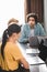 young businessman talking to female partners at table with laptops in modern