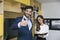Young businessman with thumb up standing with businesswoman in o
