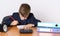 The young businessman is tired of work, draws. On the table is a calculator, next to a mini shopping trolley, a clock and folders