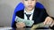 Young businessman using a laptop. Fashion child handsome boy in modern office. sits at a table in an armchair and counts money coi