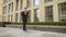 Young businessman walks down the street with a tablet.