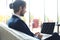 Young businessman working on laptop, sitting in hotel lobby waiting for someone.